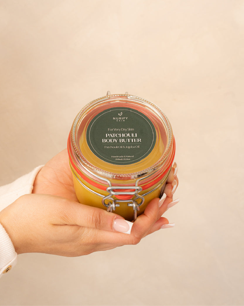 Patchouli Body Butter on a minimal background in the hand of a model, green label for eczema, dermatitis, and dry skin.